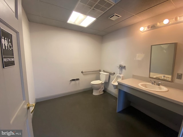 bathroom with concrete flooring, toilet, a paneled ceiling, and vanity