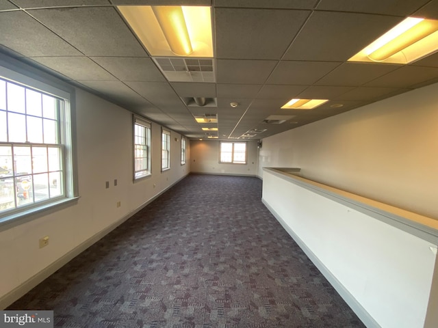 carpeted spare room featuring a paneled ceiling