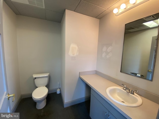 bathroom with vanity, toilet, and a paneled ceiling