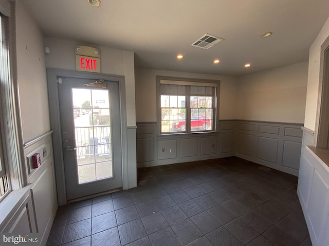 interior space featuring recessed lighting, visible vents, wainscoting, and a decorative wall