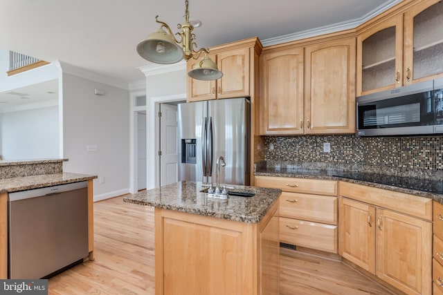 kitchen with light brown cabinetry, appliances with stainless steel finishes, light hardwood / wood-style floors, a kitchen island with sink, and ornamental molding