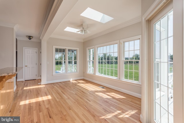 unfurnished sunroom with ceiling fan and a skylight