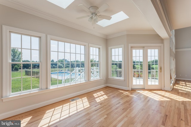 unfurnished sunroom featuring ceiling fan and a skylight