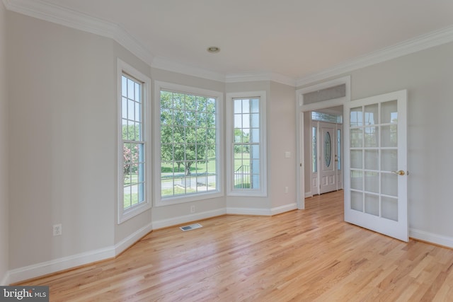 spare room featuring crown molding and light hardwood / wood-style flooring