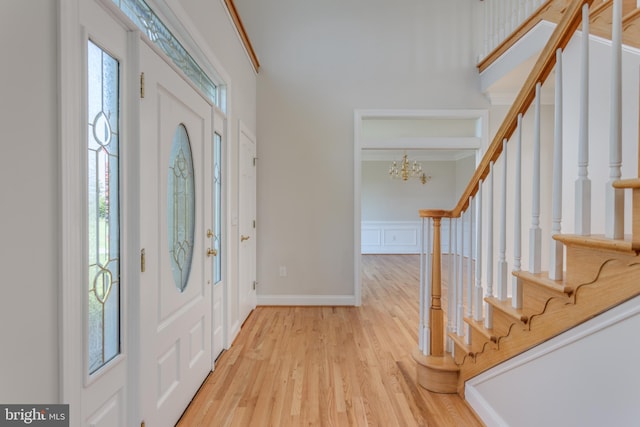 entrance foyer with crown molding, a notable chandelier, and light hardwood / wood-style flooring