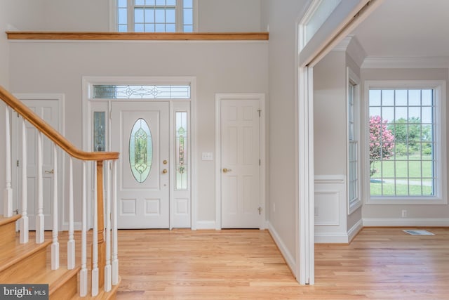 entrance foyer featuring light hardwood / wood-style floors and crown molding