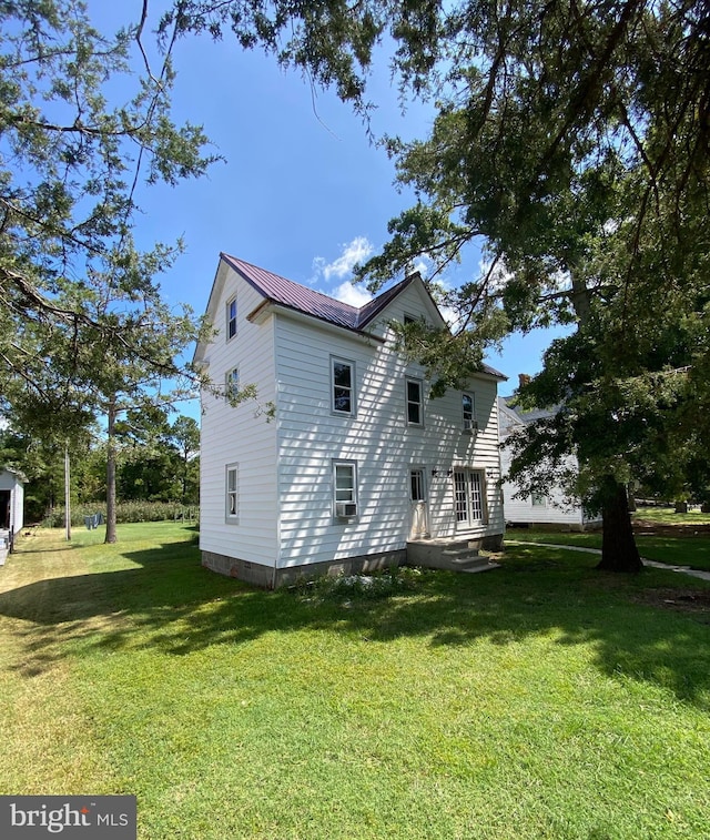 view of home's exterior featuring metal roof and a yard