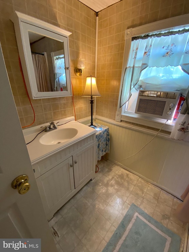 bathroom with wainscoting, cooling unit, vanity, and tile walls