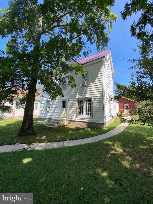 view of front of home with metal roof and a front lawn