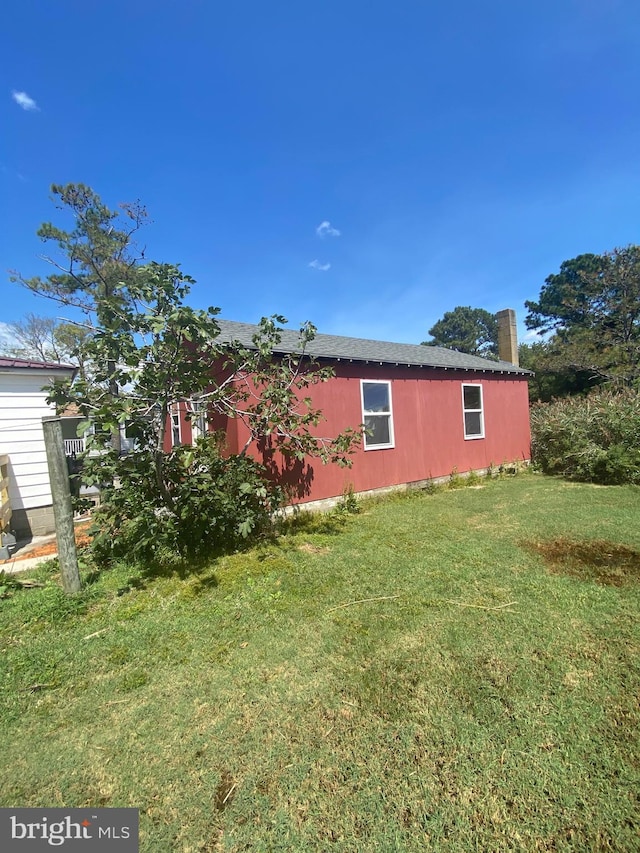 view of home's exterior with a lawn and a chimney