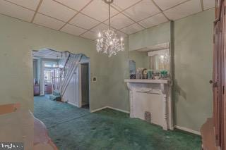 unfurnished dining area featuring a drop ceiling and carpet flooring