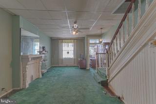 interior space featuring ceiling fan and carpet