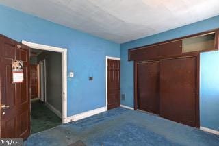 unfurnished bedroom featuring carpet floors and a closet