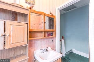 bathroom with backsplash and sink