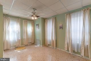 spare room with a paneled ceiling, ceiling fan, and carpet