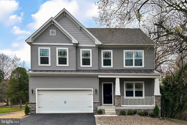 craftsman-style house with an attached garage, a standing seam roof, stone siding, and a porch