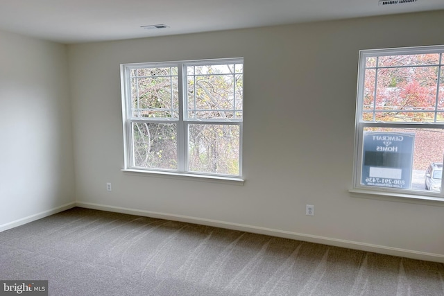 carpeted spare room with visible vents and baseboards