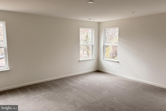 carpeted empty room featuring visible vents and baseboards