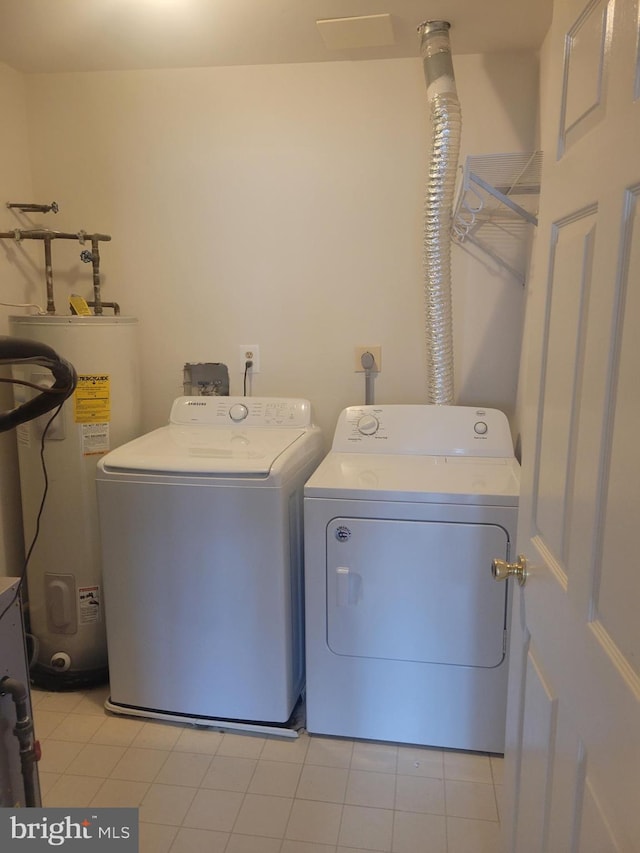 washroom with electric water heater, light tile patterned floors, and separate washer and dryer