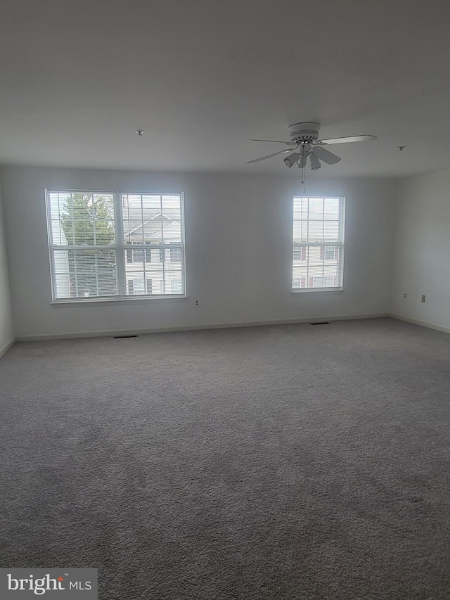 spare room featuring a healthy amount of sunlight, carpet flooring, and ceiling fan