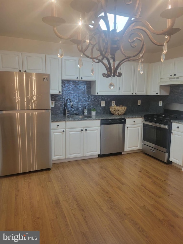 kitchen featuring light hardwood / wood-style flooring, stainless steel appliances, sink, white cabinets, and tasteful backsplash