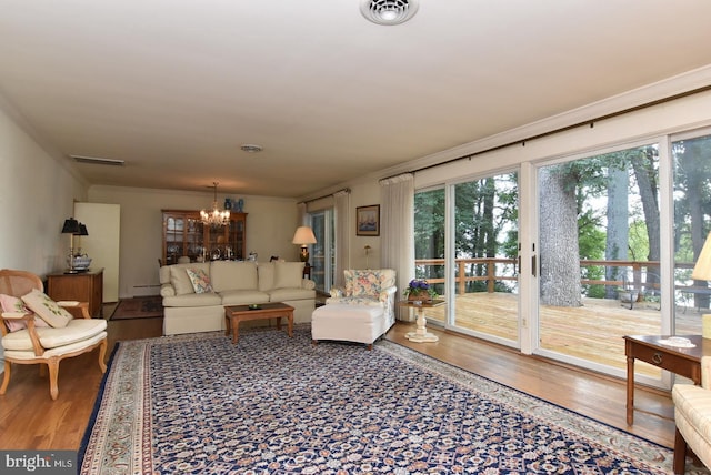 living room with ornamental molding, a chandelier, and hardwood / wood-style floors