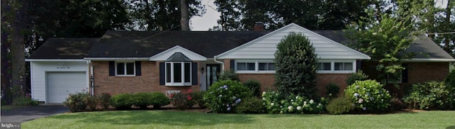 ranch-style house featuring a garage and a front yard