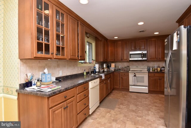 kitchen featuring backsplash, sink, and appliances with stainless steel finishes