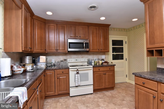 kitchen with white electric stove and tasteful backsplash