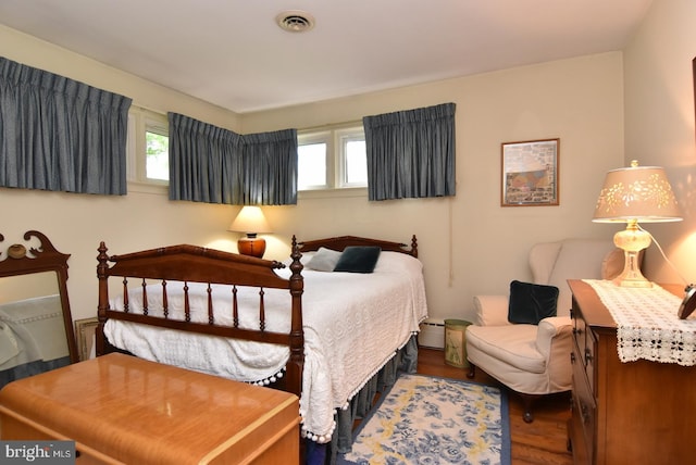 bedroom featuring dark wood-type flooring and a baseboard radiator