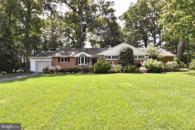 ranch-style home featuring a garage and a front lawn