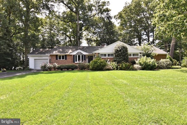 ranch-style house featuring driveway, brick siding, an attached garage, and a front yard