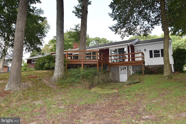 back of property featuring a chimney and a wooden deck