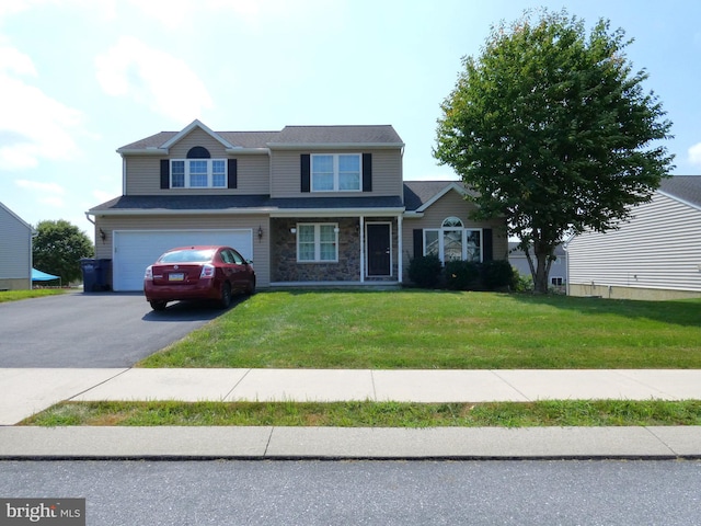 view of front of house with a front yard, stone siding, driveway, and an attached garage