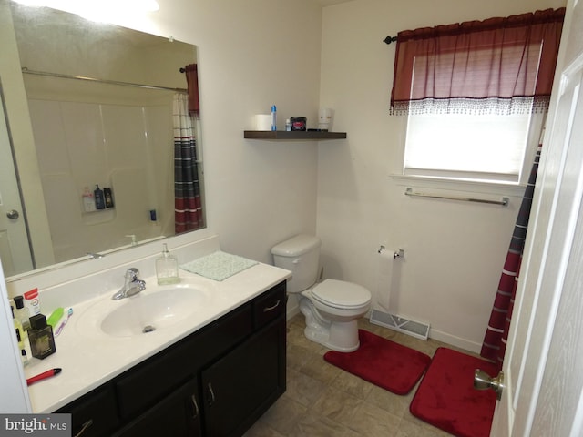 bathroom with vanity, toilet, tile patterned floors, and walk in shower