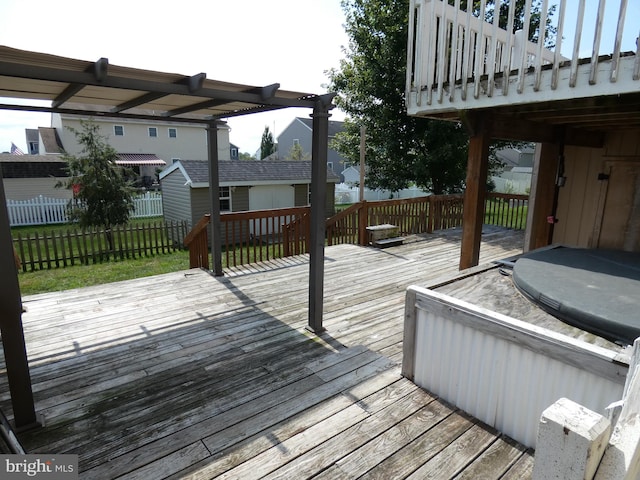 wooden terrace with an outdoor structure and a covered hot tub