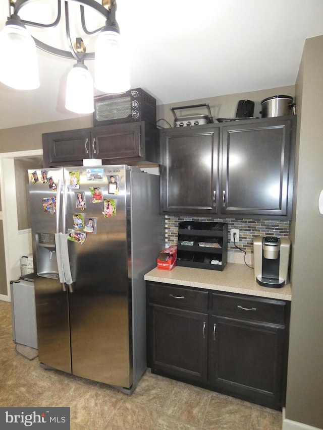 kitchen with stainless steel refrigerator with ice dispenser, light tile patterned floors, and decorative backsplash