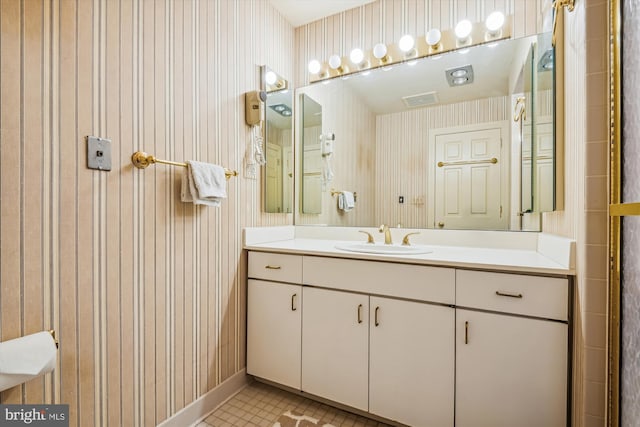 bathroom featuring baseboards, tile patterned flooring, vanity, and wallpapered walls