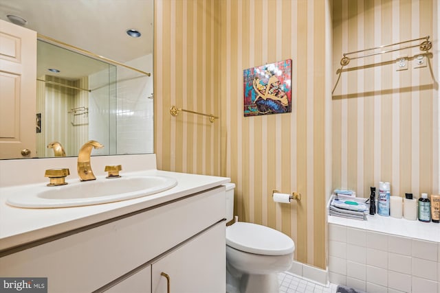 bathroom with toilet, tile patterned flooring, vanity, and wallpapered walls