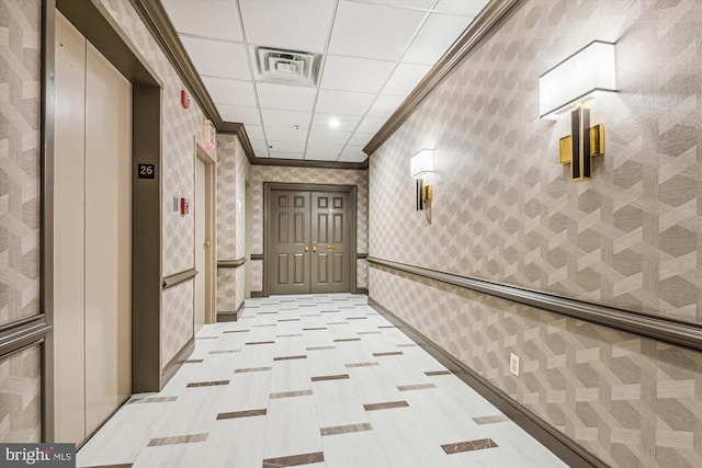 hallway featuring crown molding, a drop ceiling, elevator, and wallpapered walls