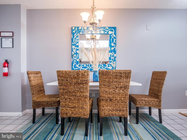 tiled dining area with baseboards and a notable chandelier