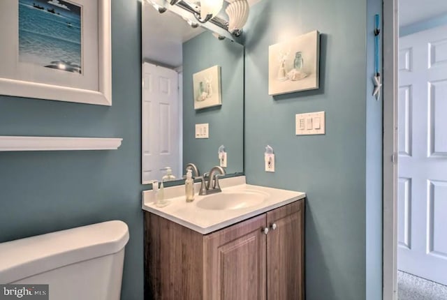 half bathroom with vanity and toilet