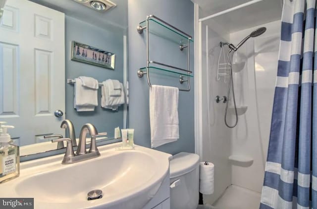 bathroom with curtained shower, vanity, and toilet