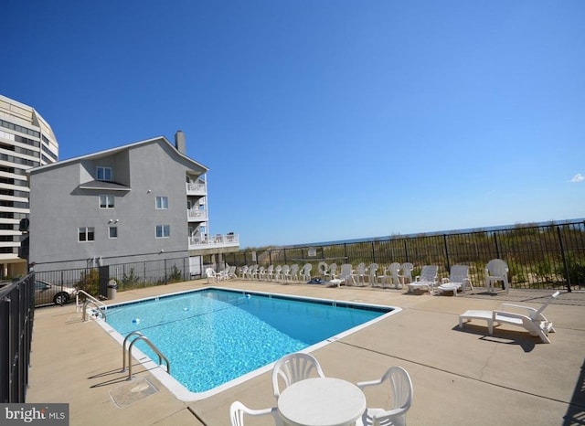 pool with a patio and fence