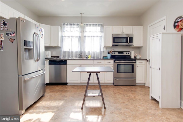 kitchen featuring decorative light fixtures, light tile patterned floors, appliances with stainless steel finishes, sink, and white cabinets