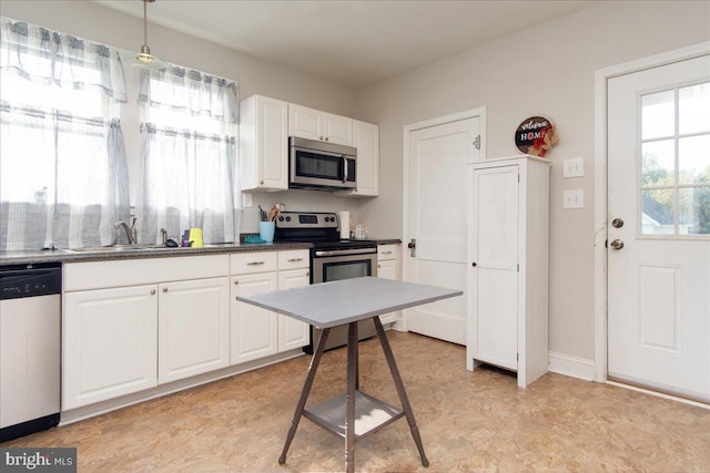 kitchen with stainless steel appliances, white cabinetry, and sink