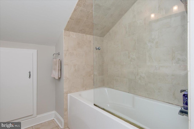 bathroom with tiled shower / bath, vaulted ceiling, and tile patterned flooring