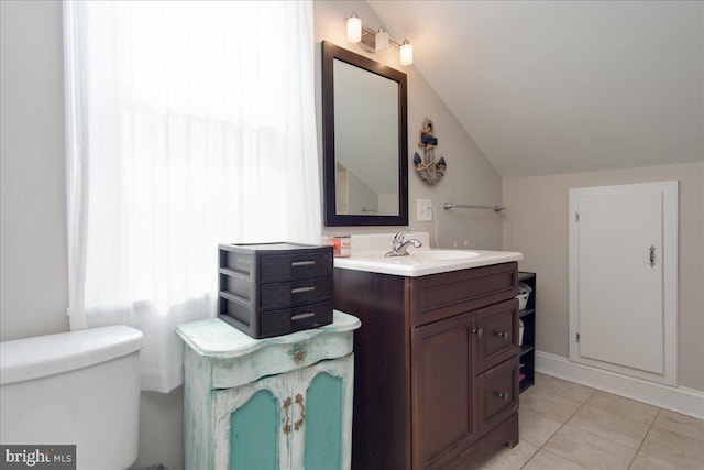 bathroom with vanity, lofted ceiling, toilet, and tile patterned flooring