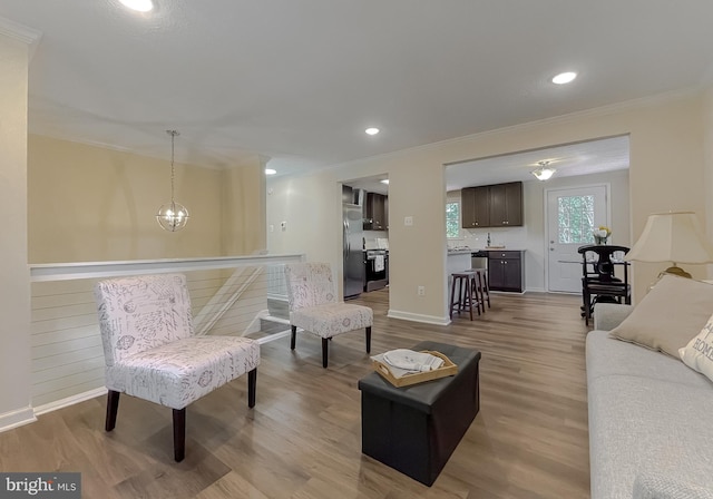 living room featuring crown molding, hardwood / wood-style floors, and a notable chandelier