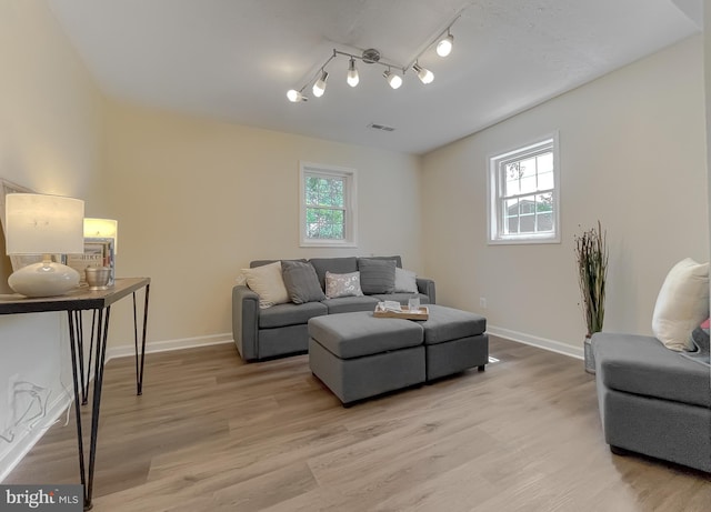 living room with light wood-type flooring and track lighting